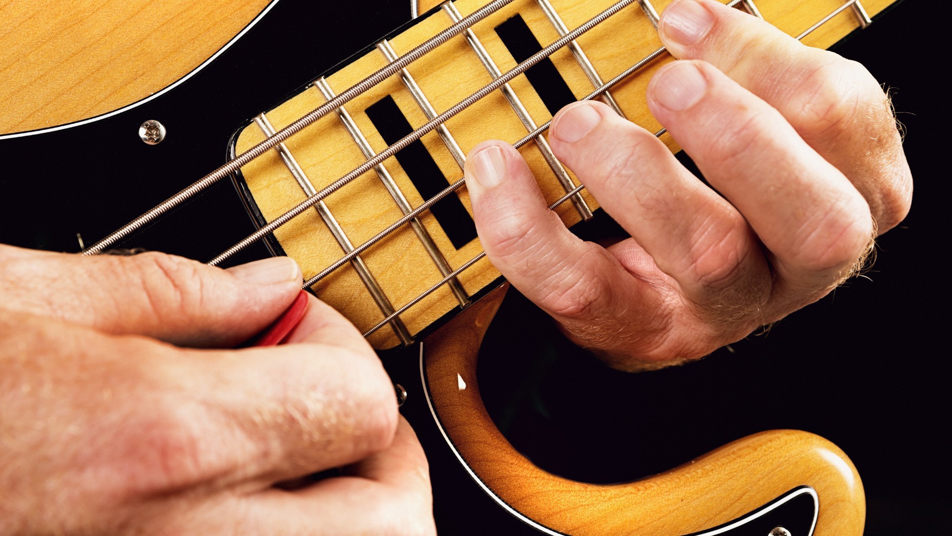 A close up of a bass player running through scales