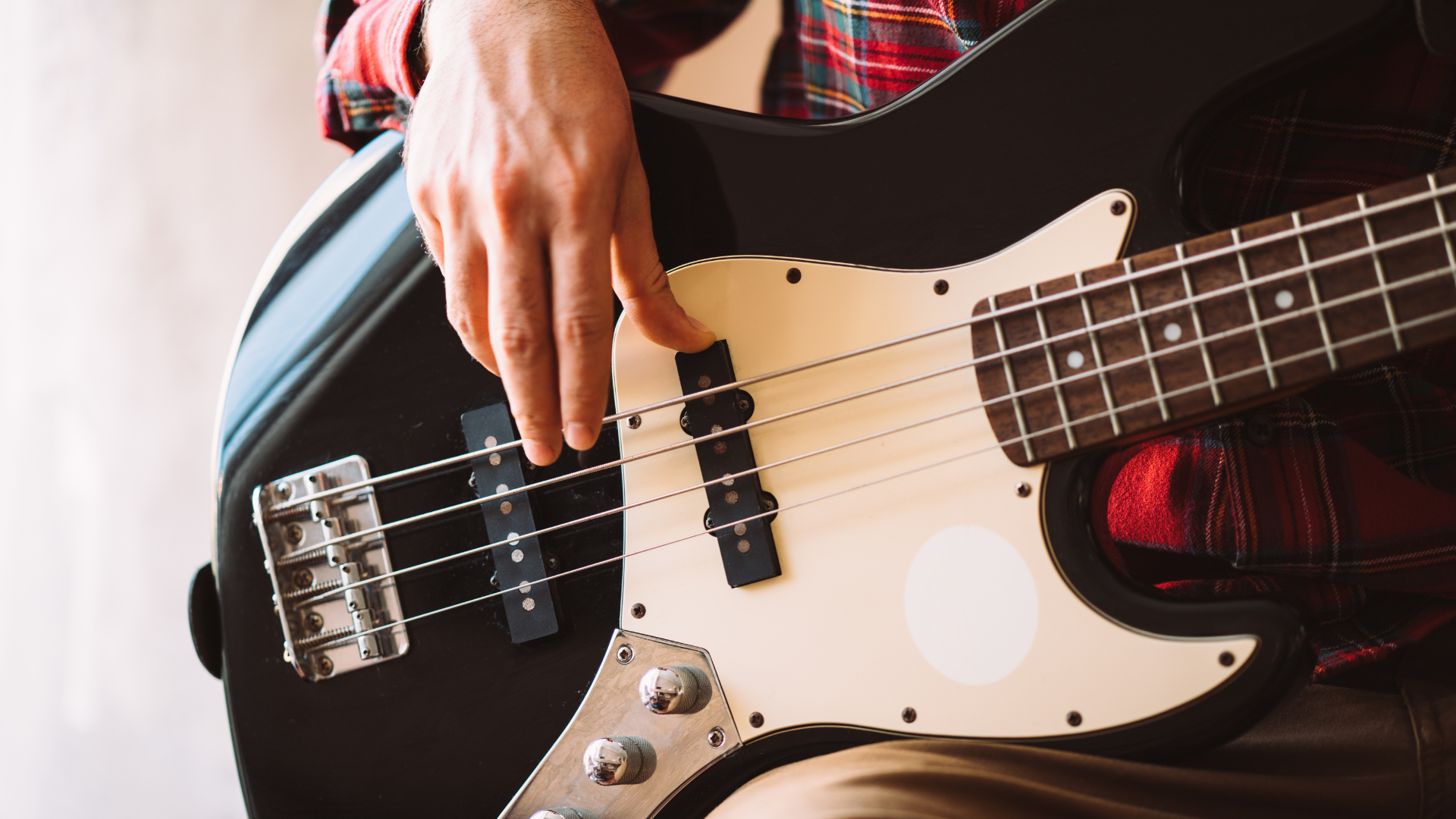 Bass player finger picking a four string guitar