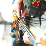 A bass player using a strap to play standing up