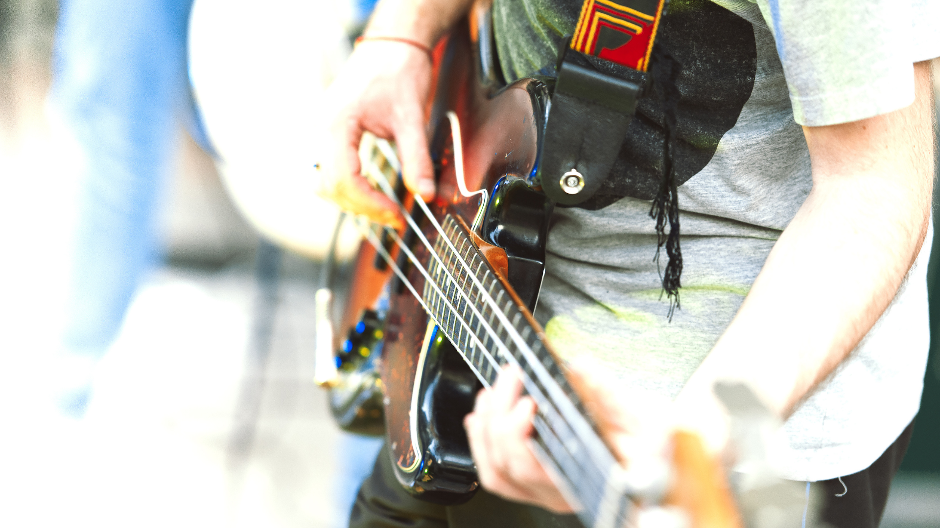 A bass player using a strap to play standing up