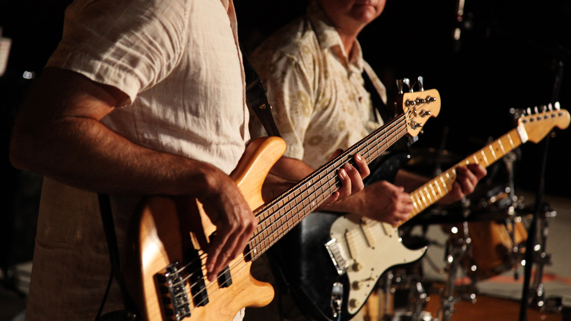 A guitarist and bass player in a blues band on stage