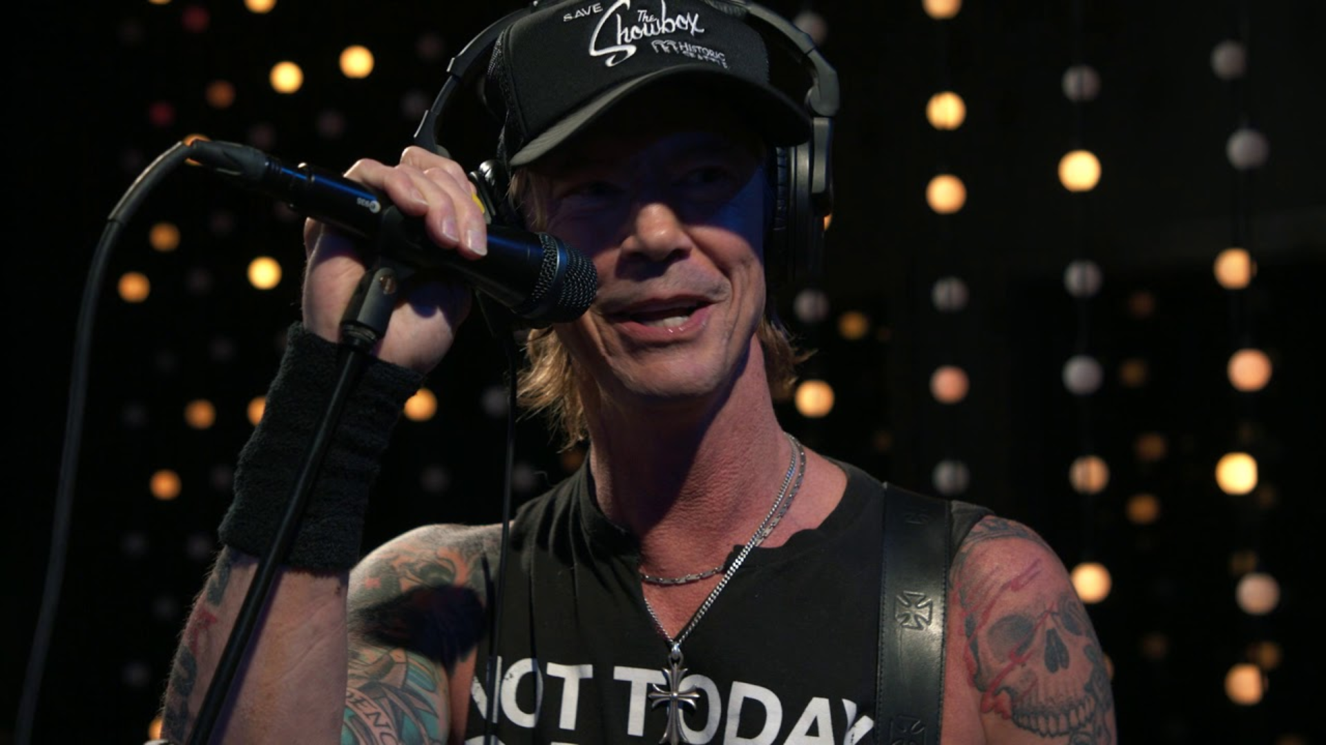 Duff McKagan on stage speaking into a microphone