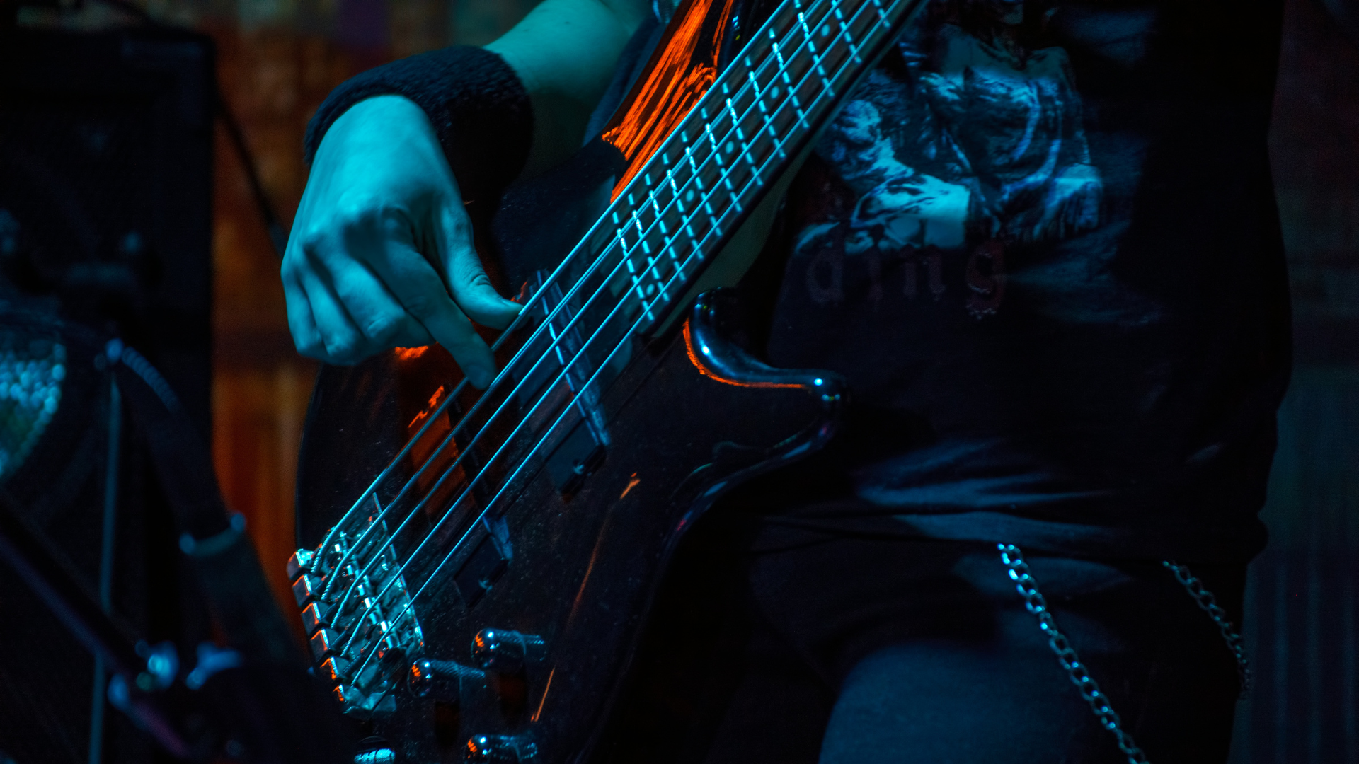 A bass player on stage with a 5 string playing metal music