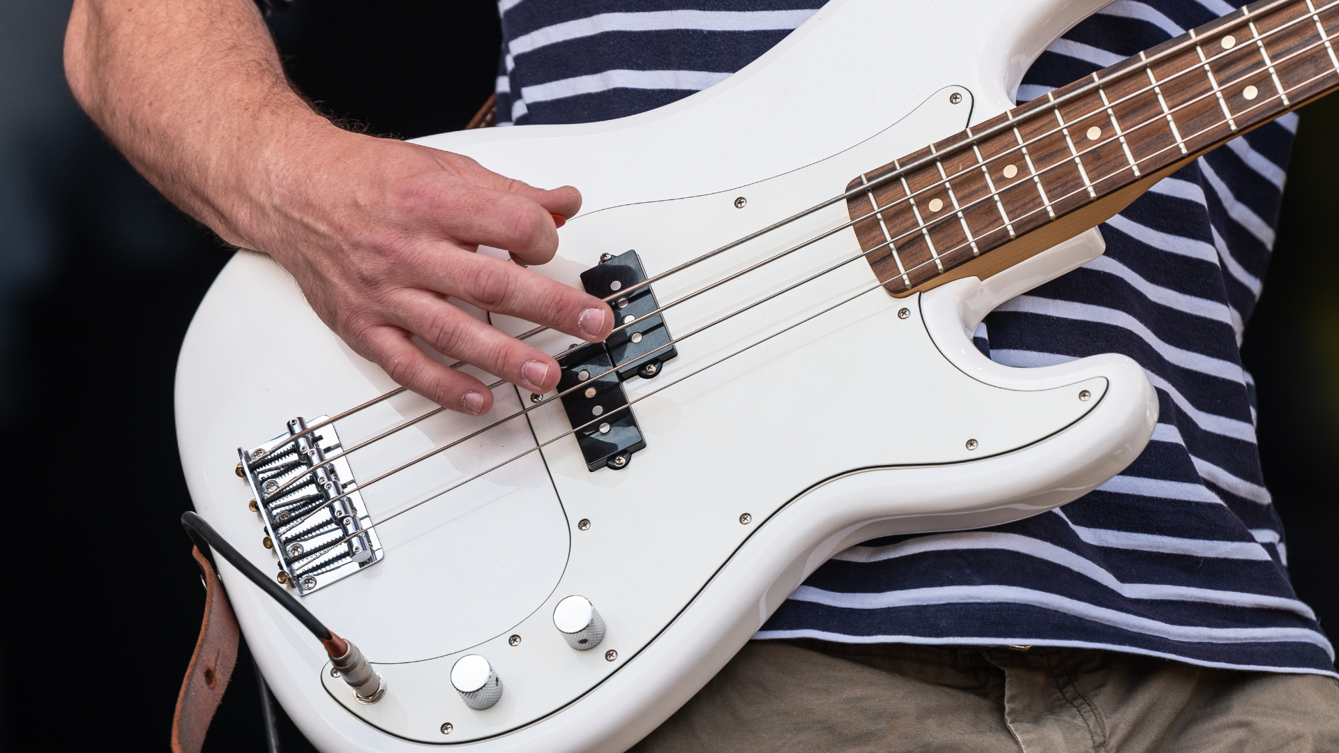 Bass player on stage with a Fender shaped guitar