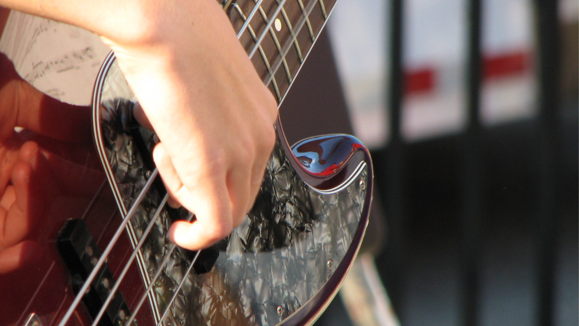 Close up of a bass player's hand near the pickups