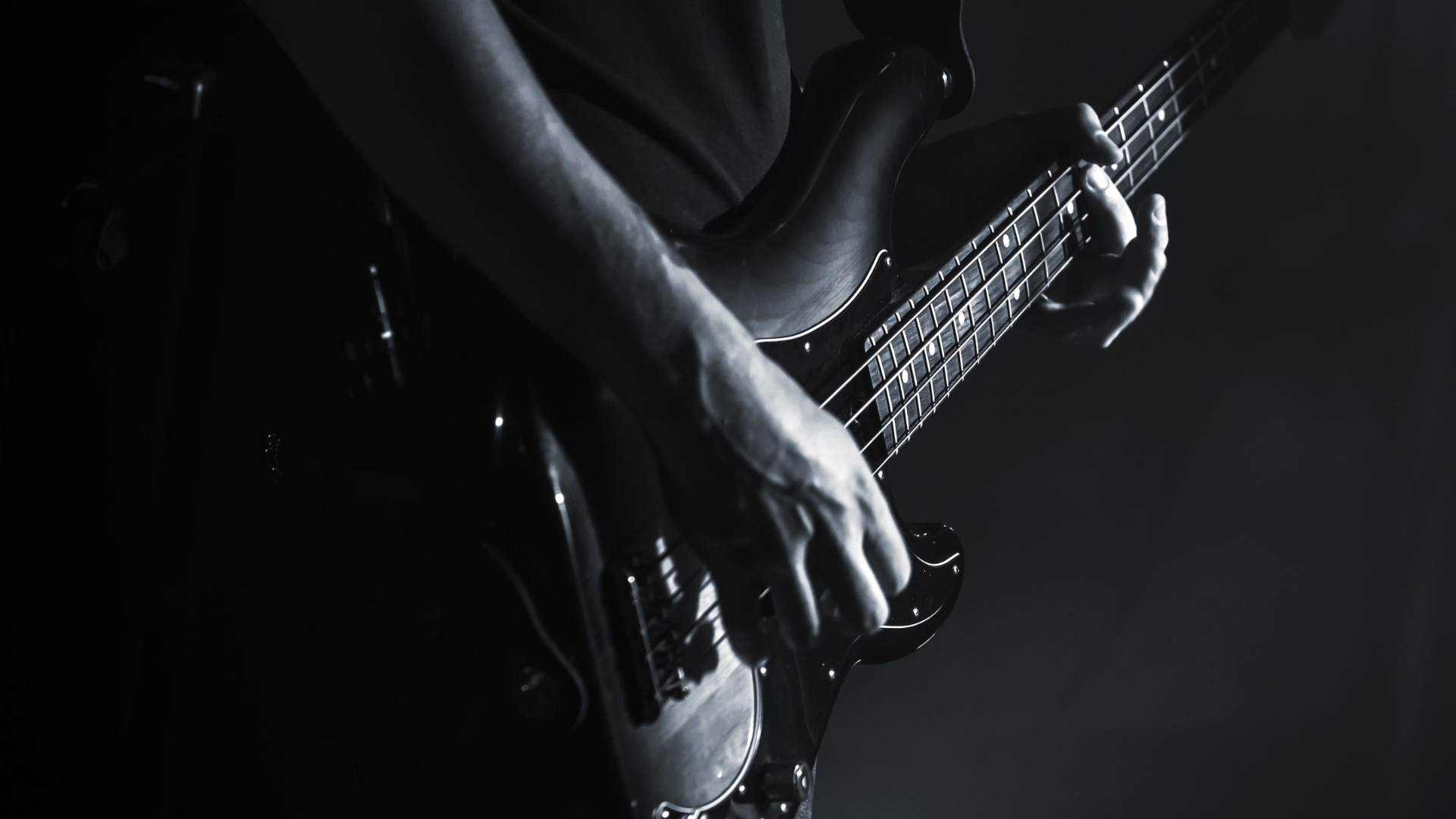 A bass guitar being played in a dark room