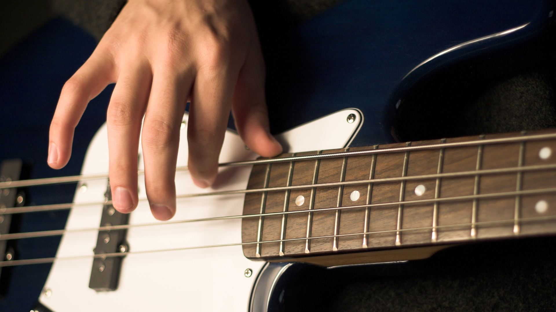 Close of a bass player's right hand over the strings